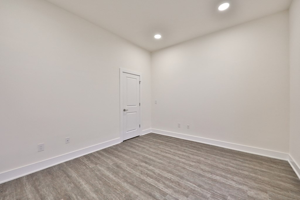 an empty living room with white walls and a white door