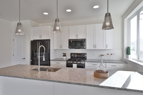 a kitchen with white cabinets and a granite counter top