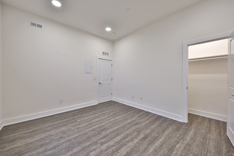 an empty living room with white walls and wood flooring