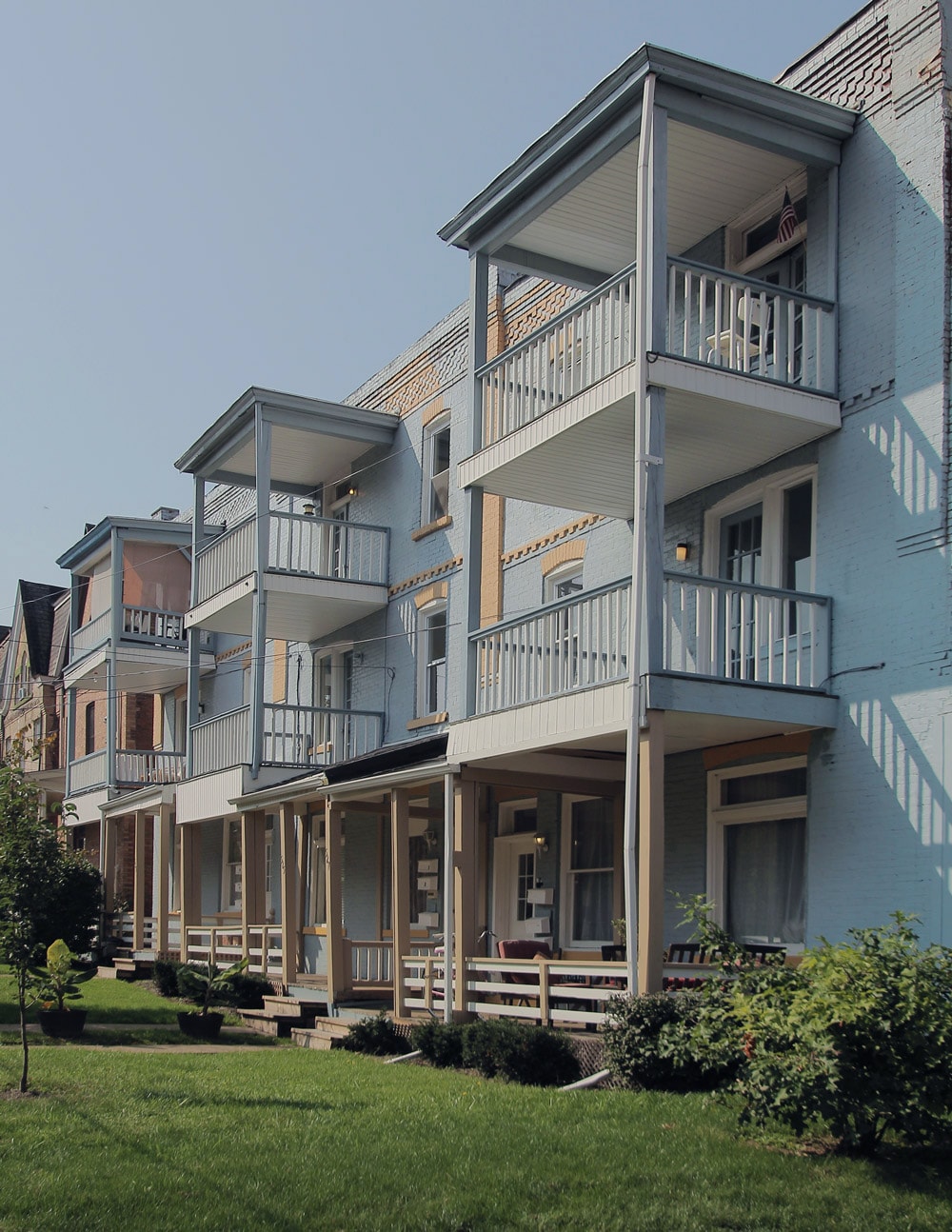 A row of houses with balconies and flower pots.