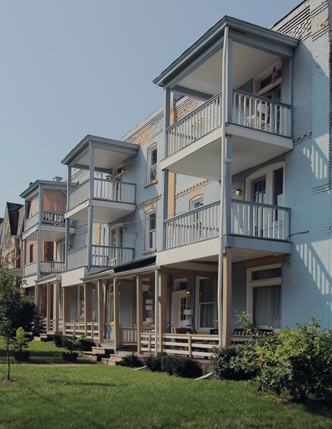 A row of houses with balconies and flower pots.