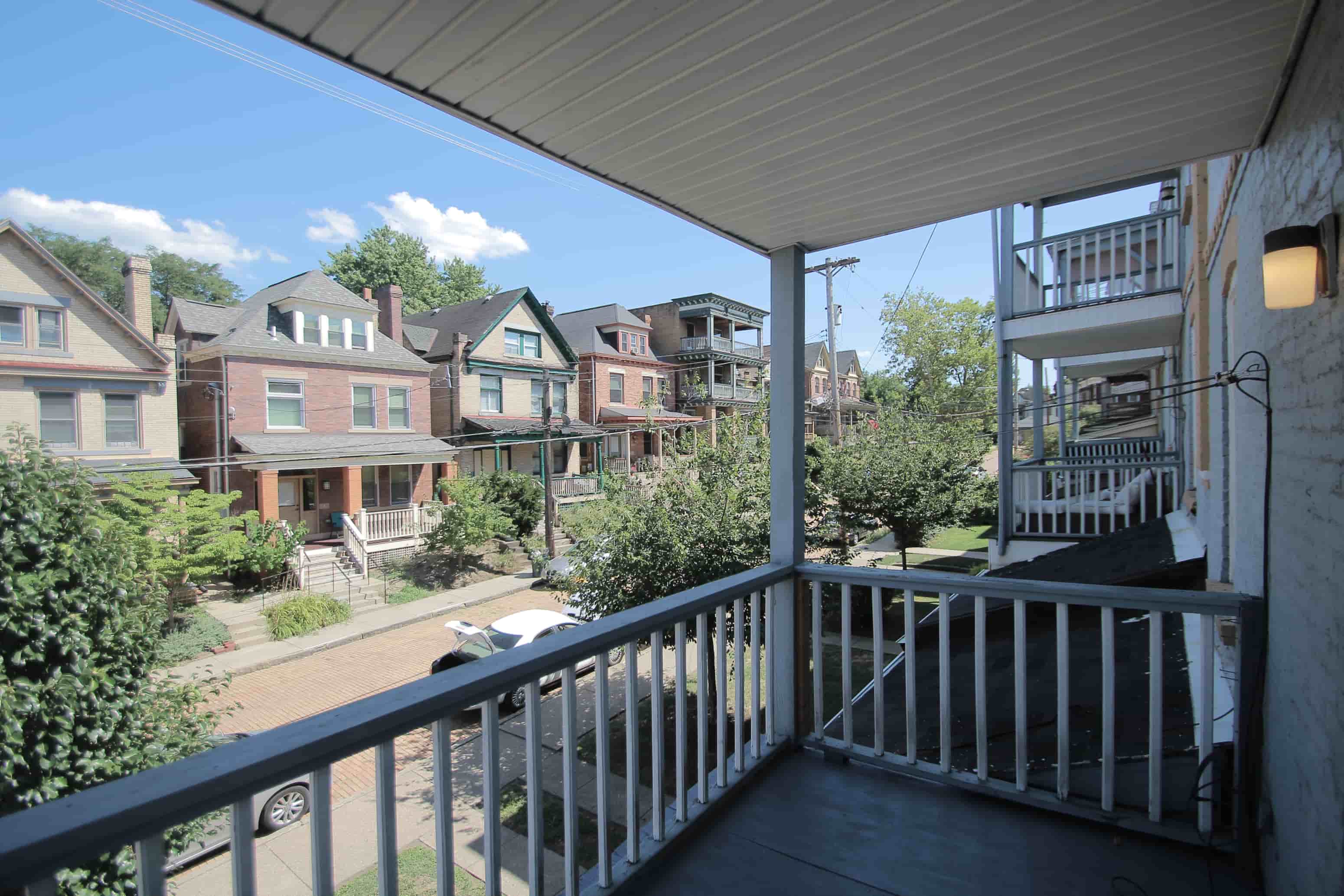 A balcony overlooks a residential street.