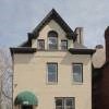 A beige house with a green awning.
