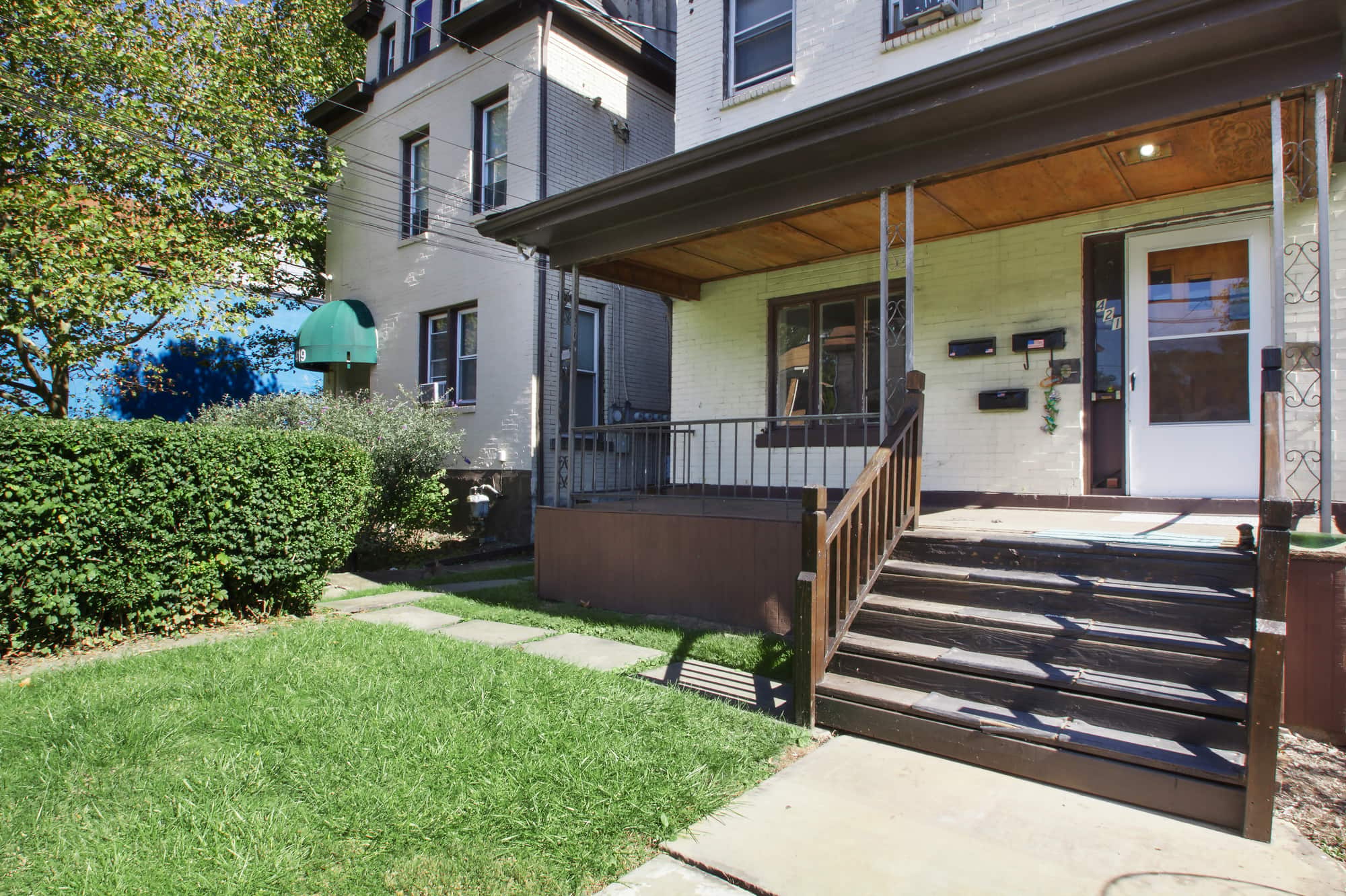 A house with a green lawn and a brown wooden fence.
