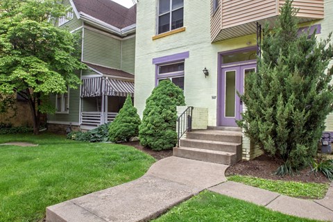 A house with a purple door and a green lawn.