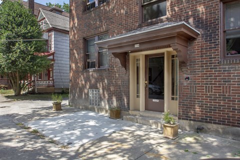 A brick building with a brown door and windows.