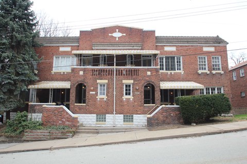 A red brick building with a white cross on the front.