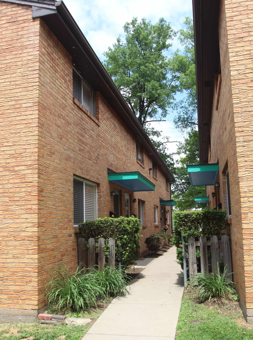 a sidewalk in front of a brick building