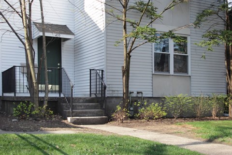 the front of a house with steps and a sidewalk