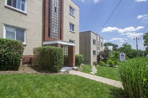 A residential building with a green lawn in front.