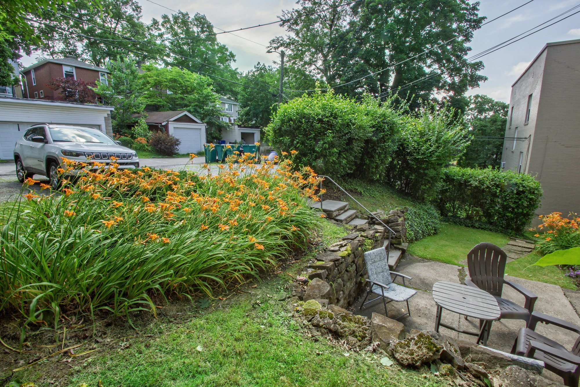 A garden with a bench and flowers in the foreground.