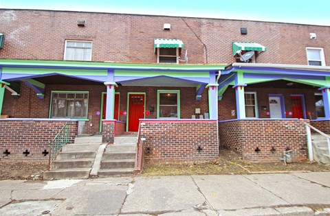 A red door is on the left side of the building.
