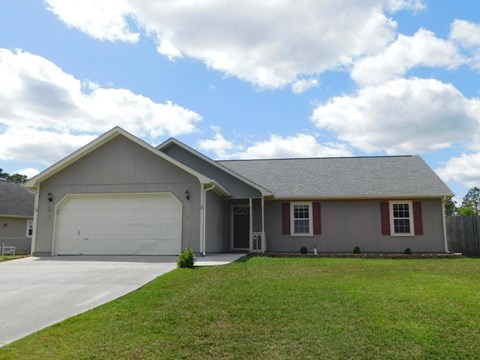 A house with a grey roof and a white garage door.