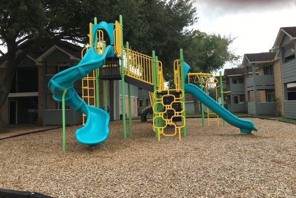 a playground with two slides and a swing set