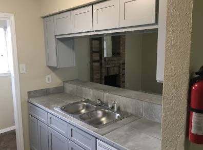 a kitchen with a sink and a mirror