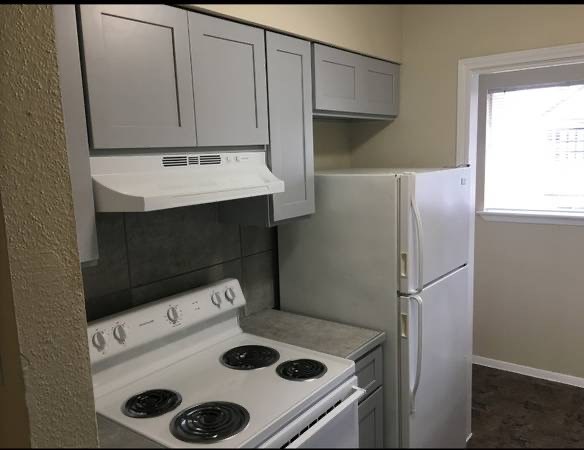 a white kitchen with a stove and a refrigerator