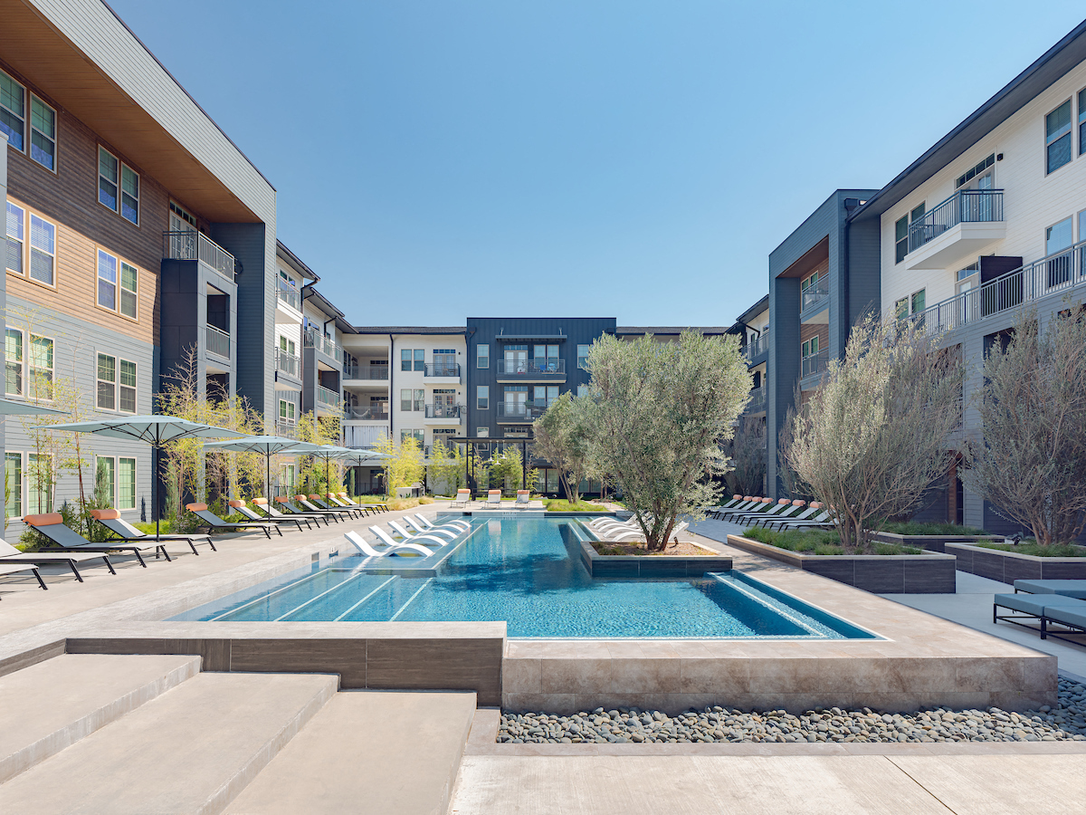 A swimming pool in a courtyard surrounded by buildings.