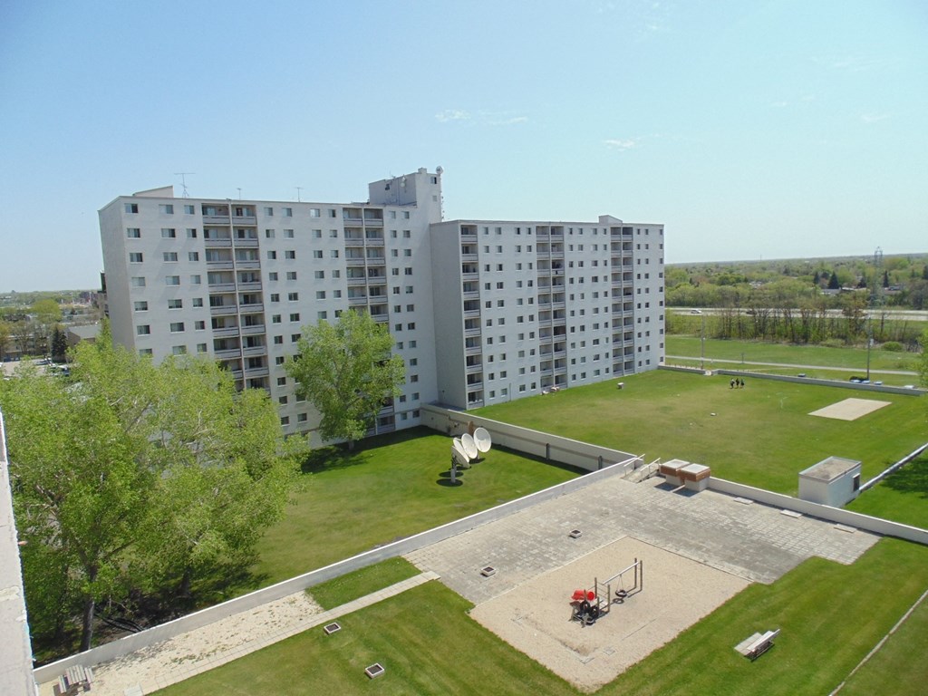 an aerial view of a building with a park and a playground
