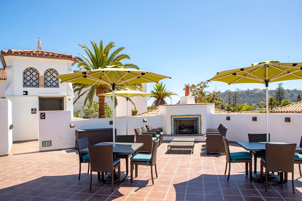 a patio with tables and chairs and umbrellas