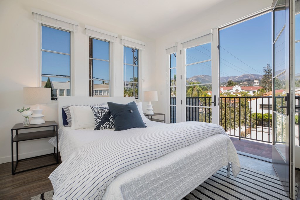 a bedroom with a bed and large windows
