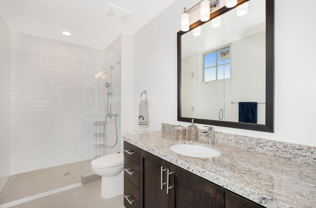 a bathroom with a shower and a sink and a mirror