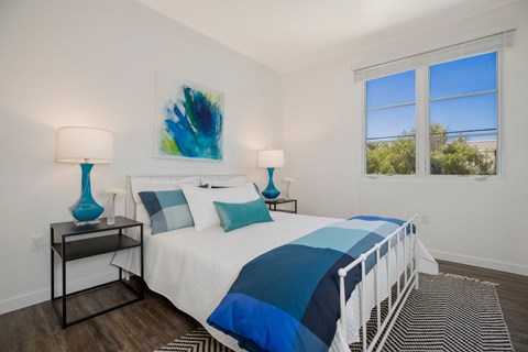 a bedroom with a large bed and two windows