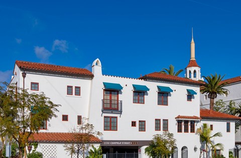 a white building with a steeple and palm trees
