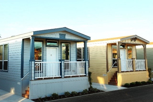 a small white house with a porch and a door