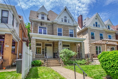 A house with a front porch and a white picket fence.