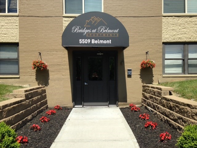 the front entrance of a building with a blue awning