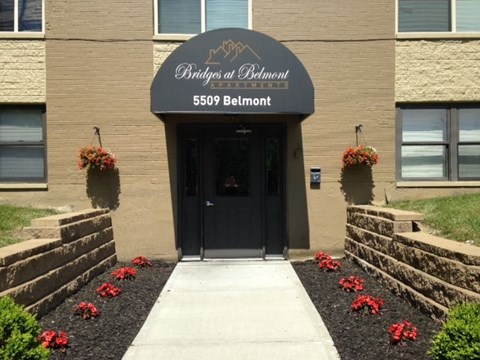the front entrance of a building with a blue awning