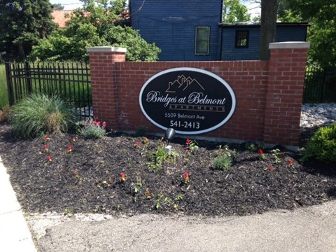 a brick sign in front of a brick wall