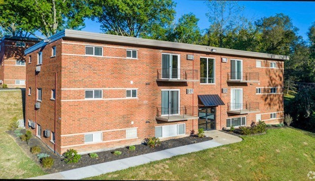 a red brick apartment building with a sidewalk