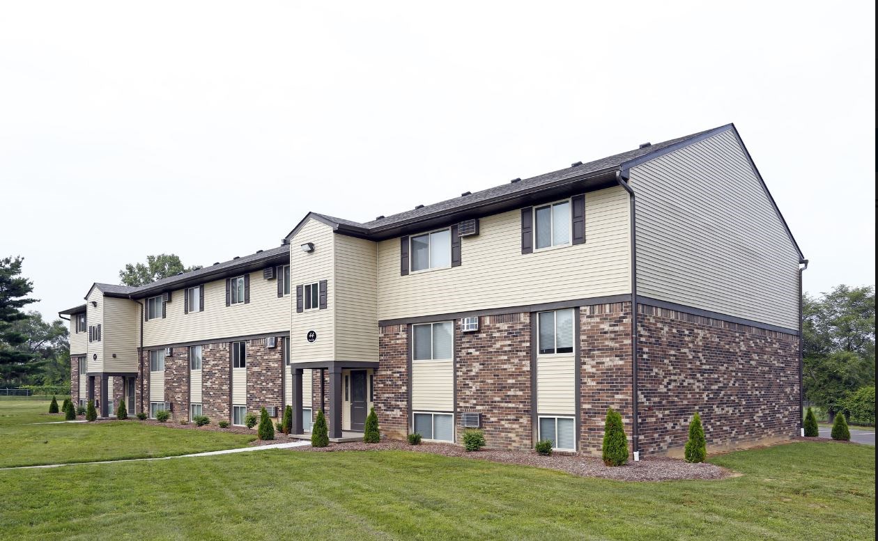 an apartment building with stone and wood siding
