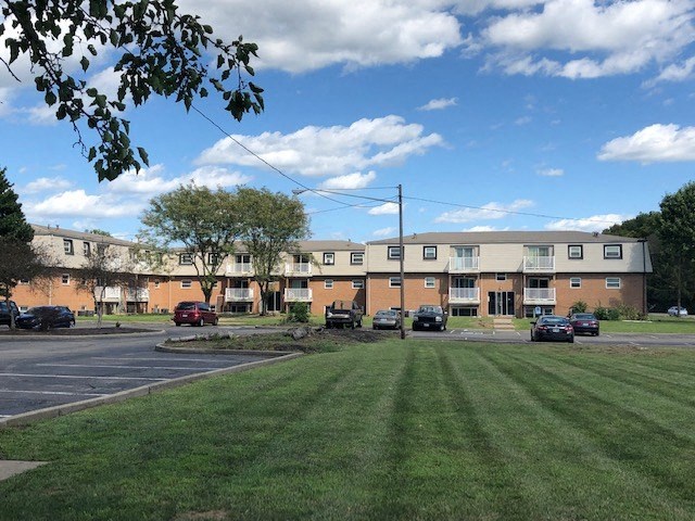 a green lawn in front of an apartment building