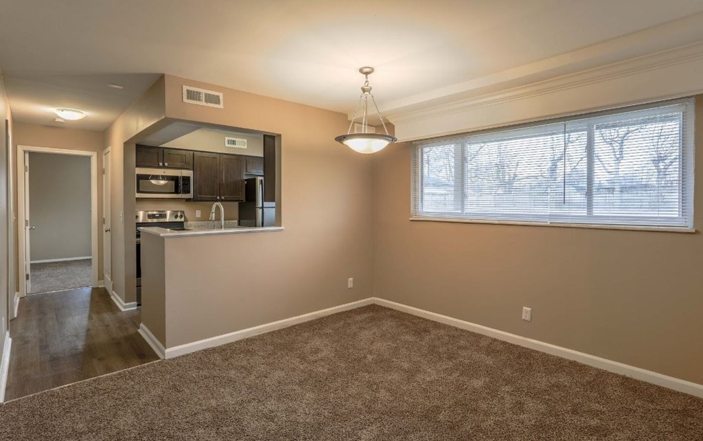 an empty room with a kitchen and a window