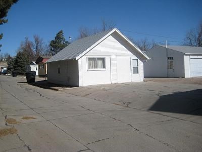 a small white house sitting in a parking lot