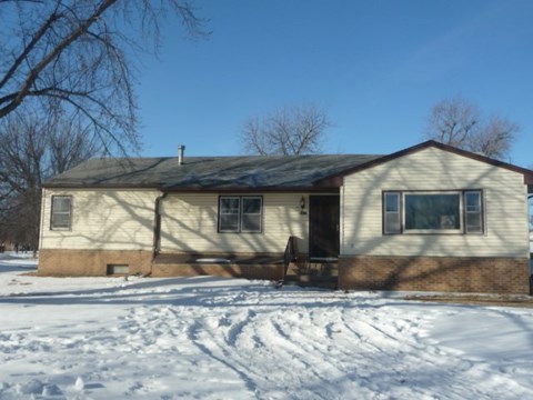 a house in the snow with the front door open