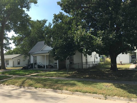 a white house with a tree in front of it