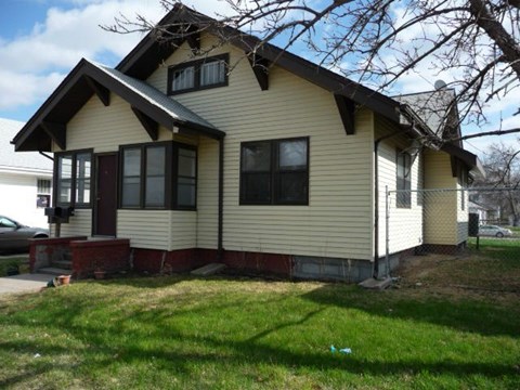 a yellow house with a yard in front of it