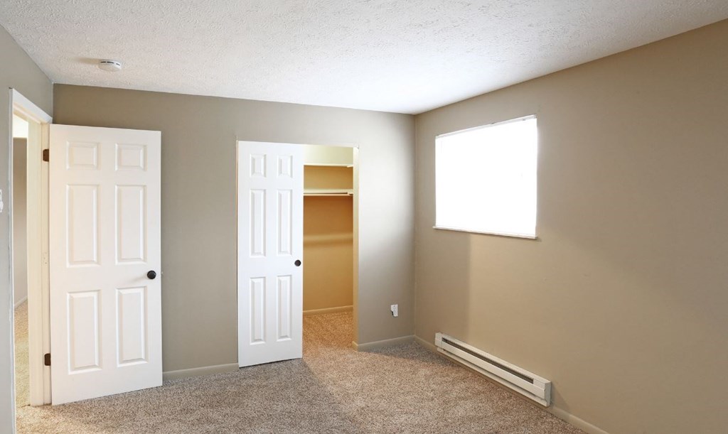 an empty living room with two doors and a window