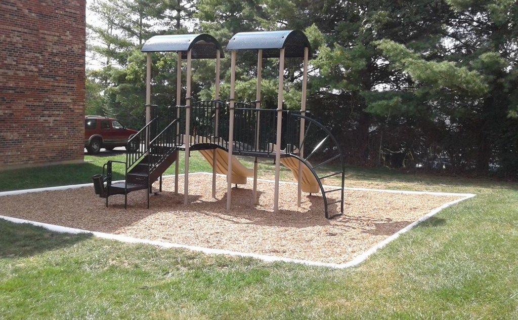 a playground in a yard with a swing set