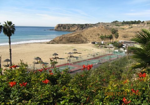 a view of the beach and the ocean from a hill