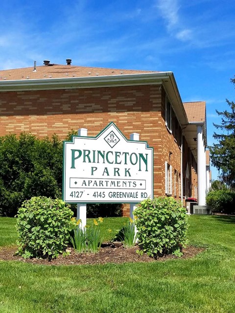 a sign apartments in front of a brick building