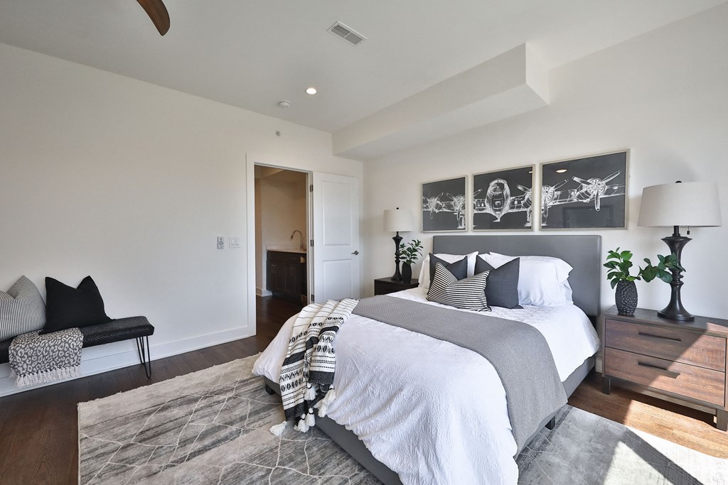 the master bedroom has a large bed and white blankets and pillows