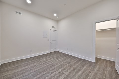 an empty living room with white walls and a door to a closet