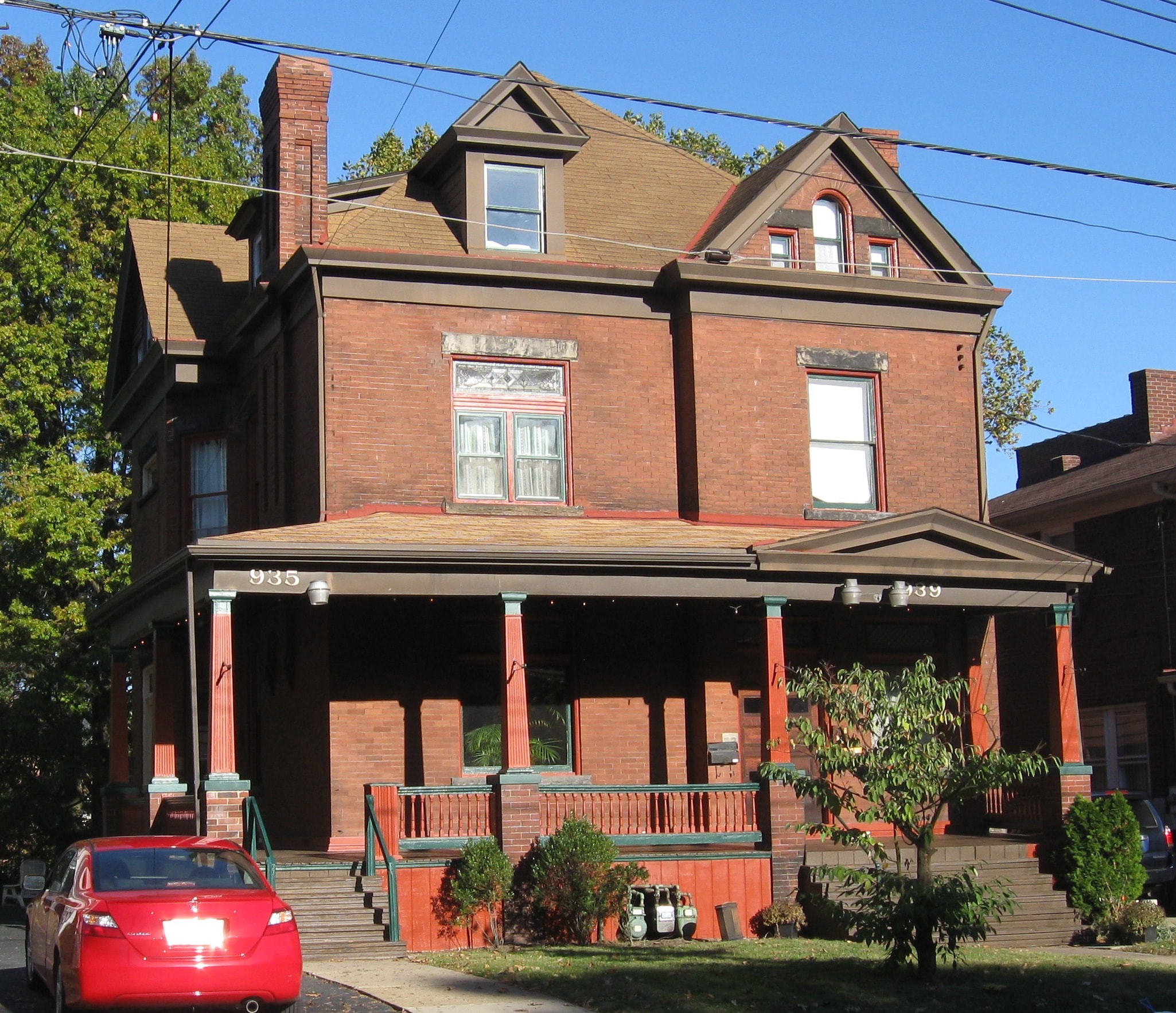 a red brick house with a red car parked in front of it