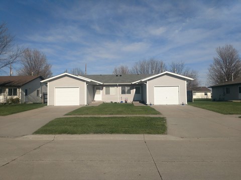 the front of a house with a driveway and a lawn