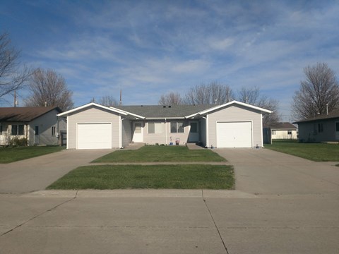 a house with white garage doors and a driveway