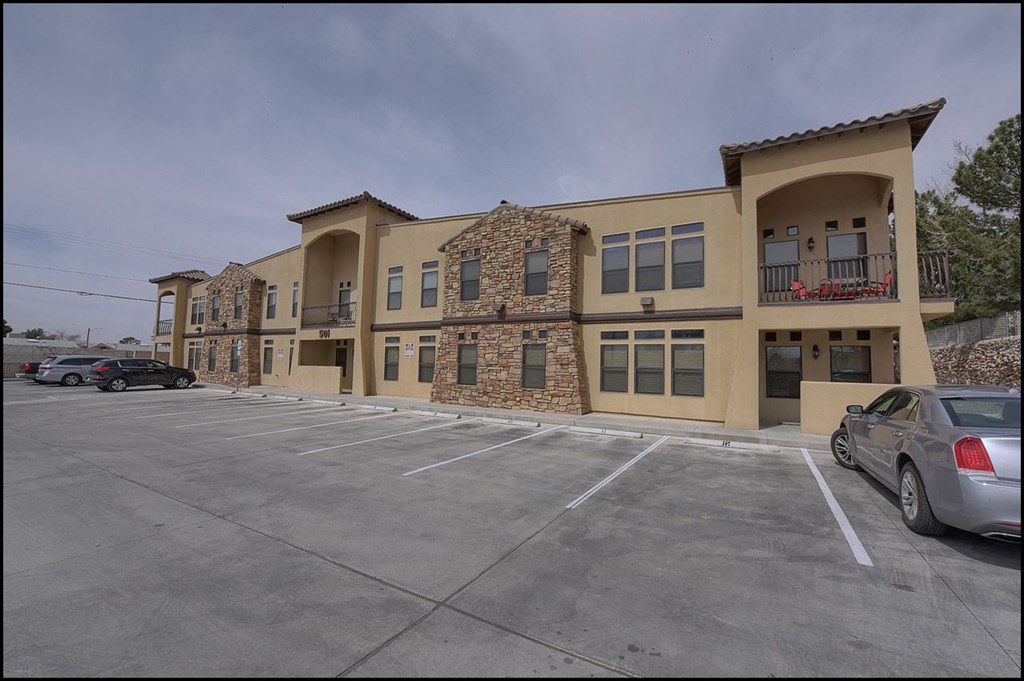 a parking lot in front of a building with cars parked